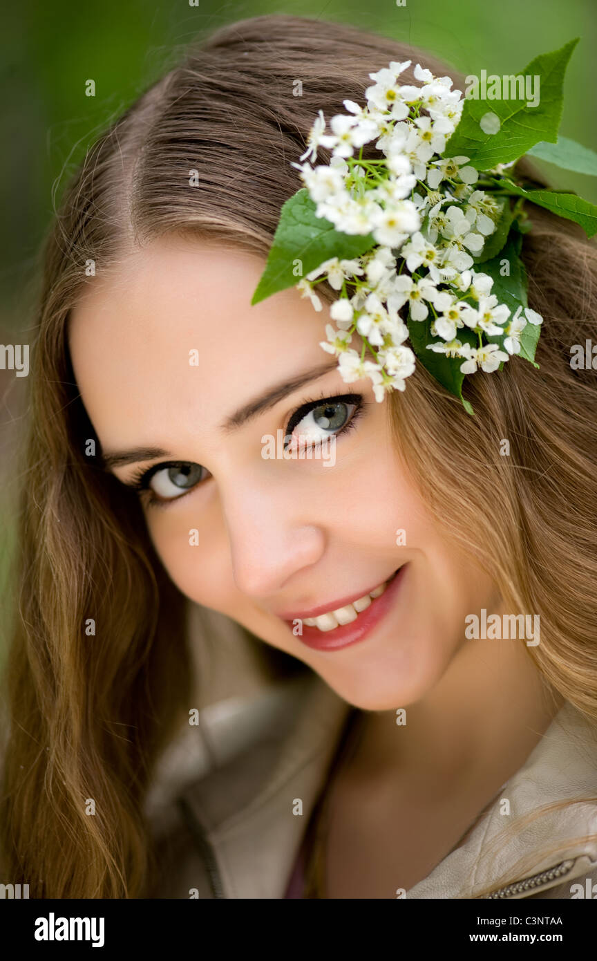 junges Mädchen mit Blumen im Haar in einen Sommerpark Stockfoto