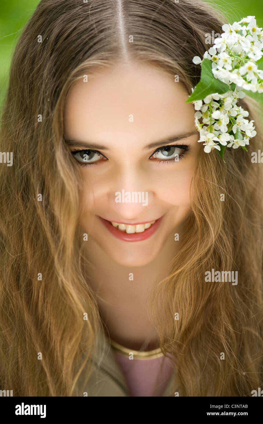 junges Mädchen mit Blumen im Haar in einen Sommerpark Stockfoto