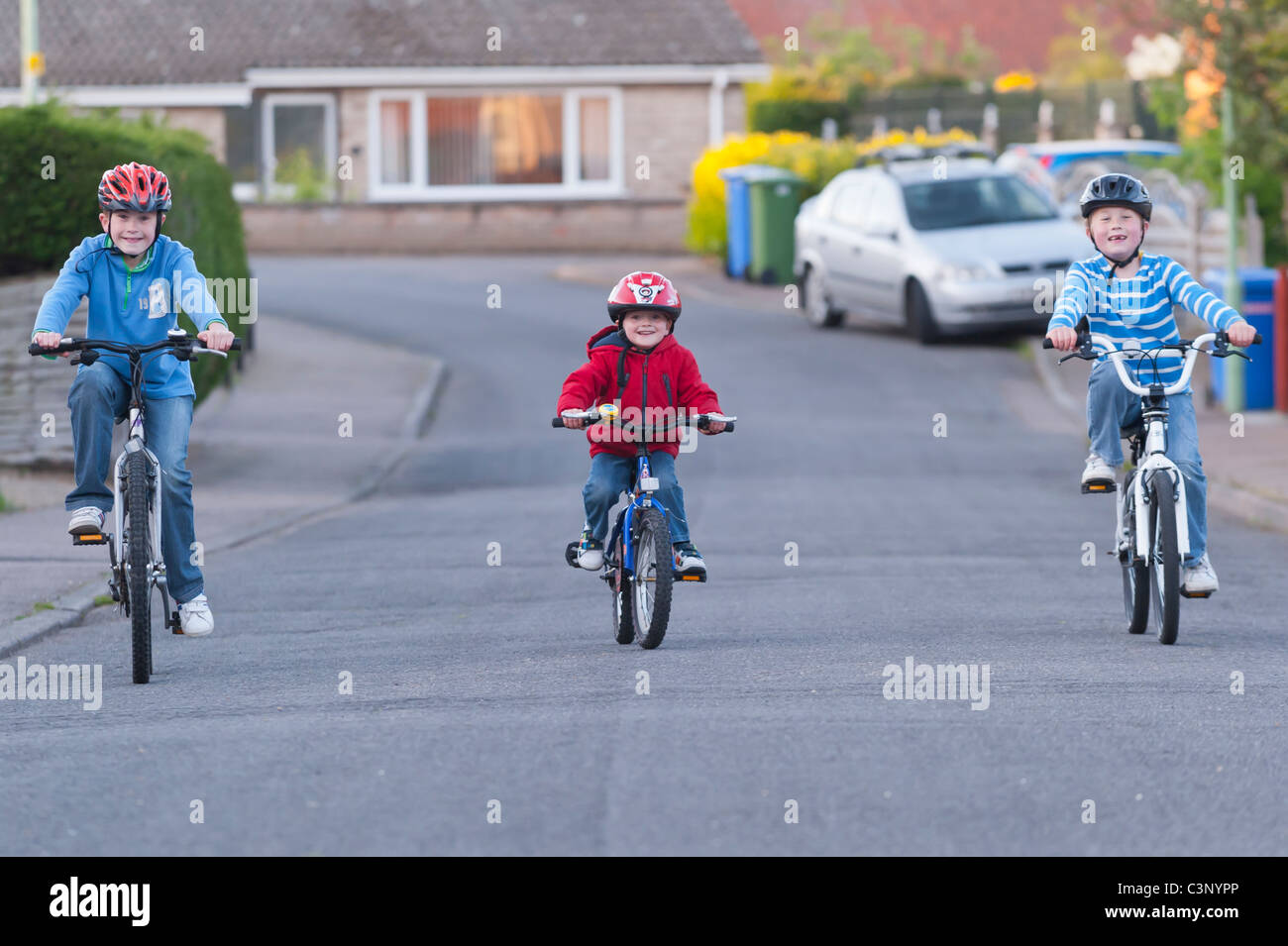 Drei Jungs reiten ihre Fahrräder in einer uk-Straße Stockfoto