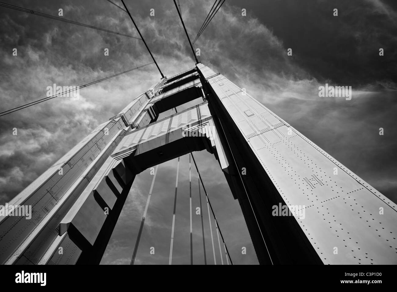 Ein niedriger Winkel des Turms der Golden Gate Bridge, der die Höhe des Gebäudes und die Kabel zeigt, die die Brücke stützen. Stockfoto