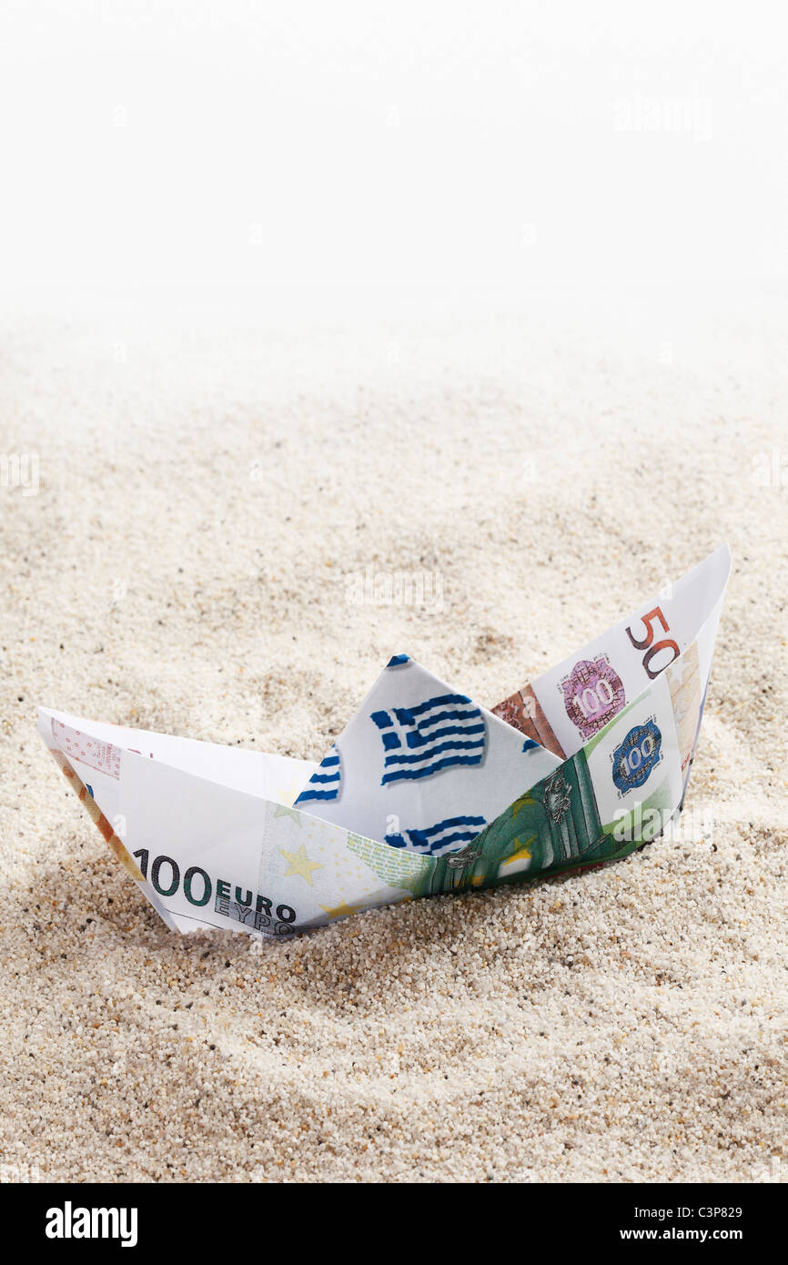 Origami Papierboot von Euro-Banknoten auf sand Stockfoto