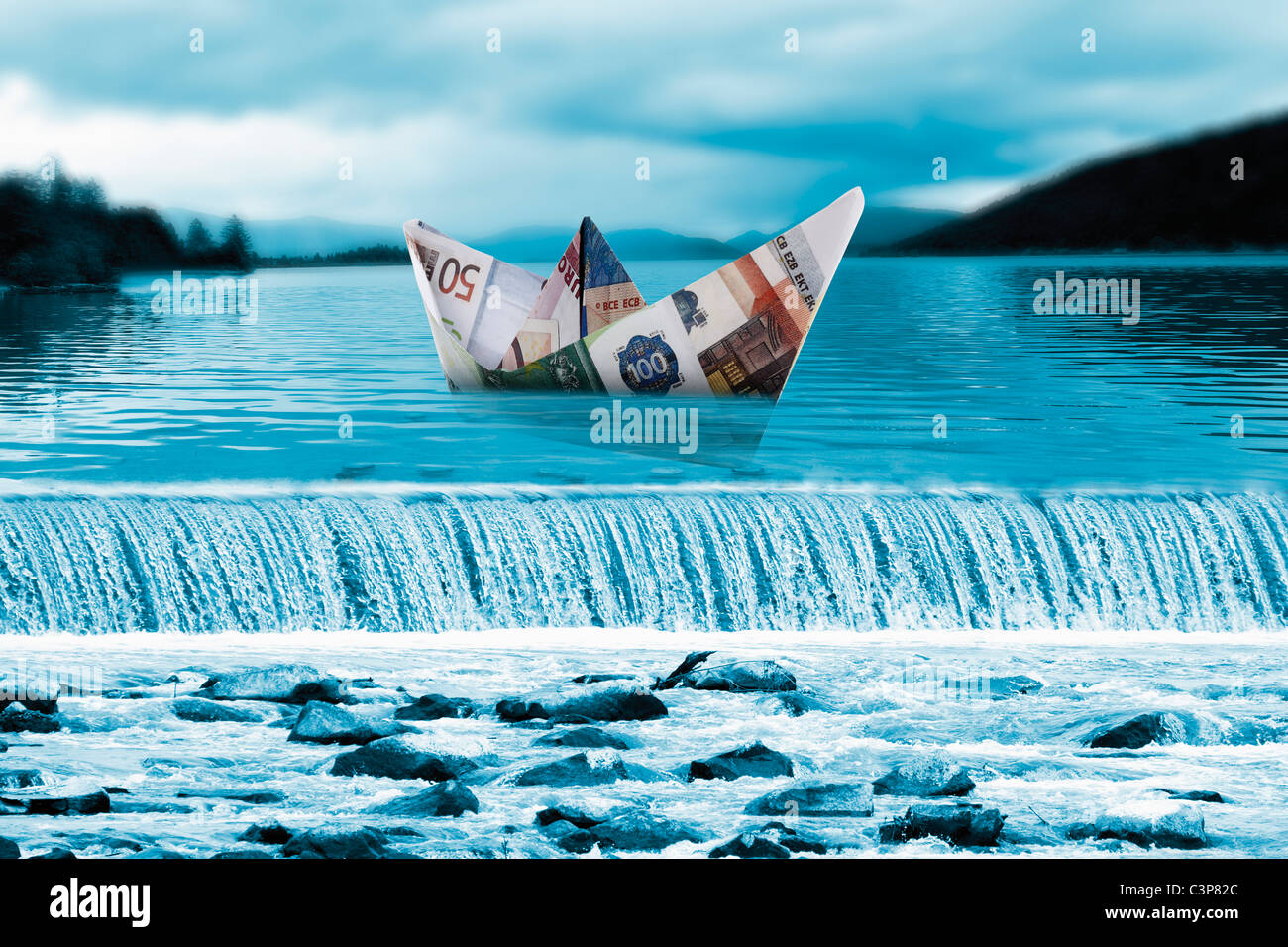 Origami Papierboot von Euro-Banknoten am Wasserfall Stockfoto