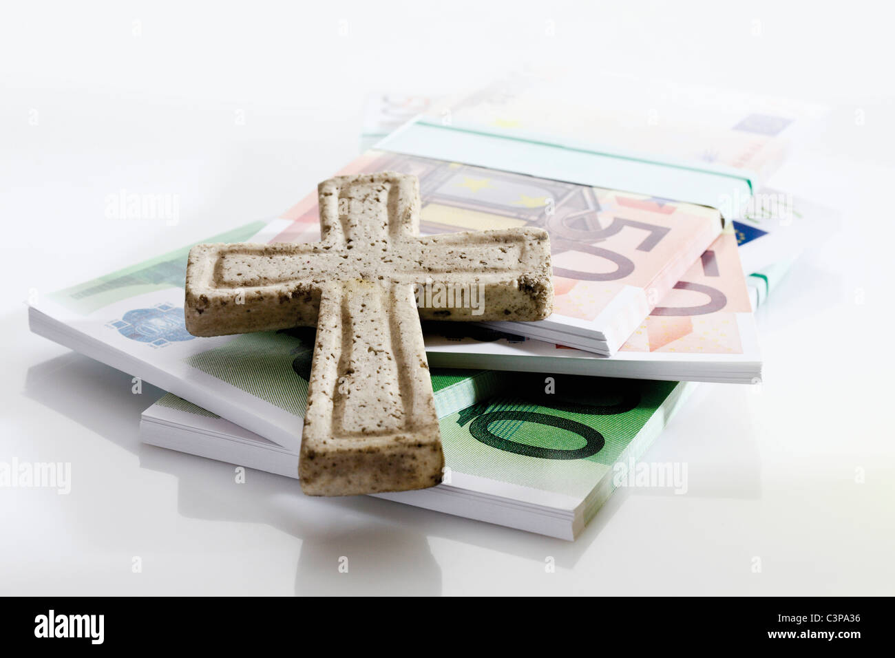 Bündel von Euro-Noten mit auf weißem Hintergrund Kreuz Stockfoto