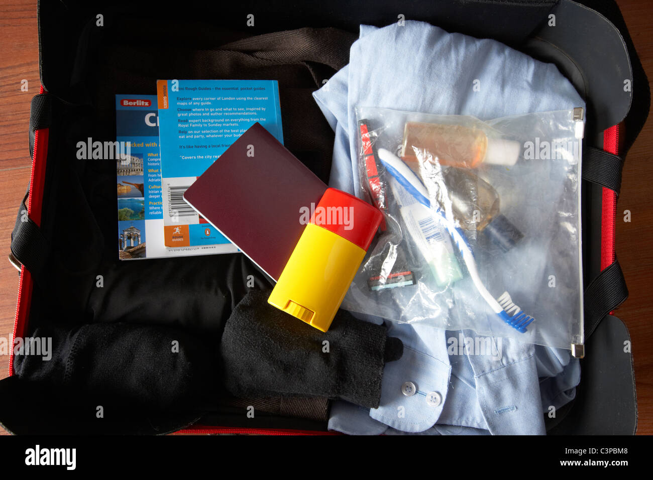 Gepäck verpackt für eine Geschäftsreise, einschließlich Pass und Toilettenartikel im durchschauen Plastiktüte Stockfoto