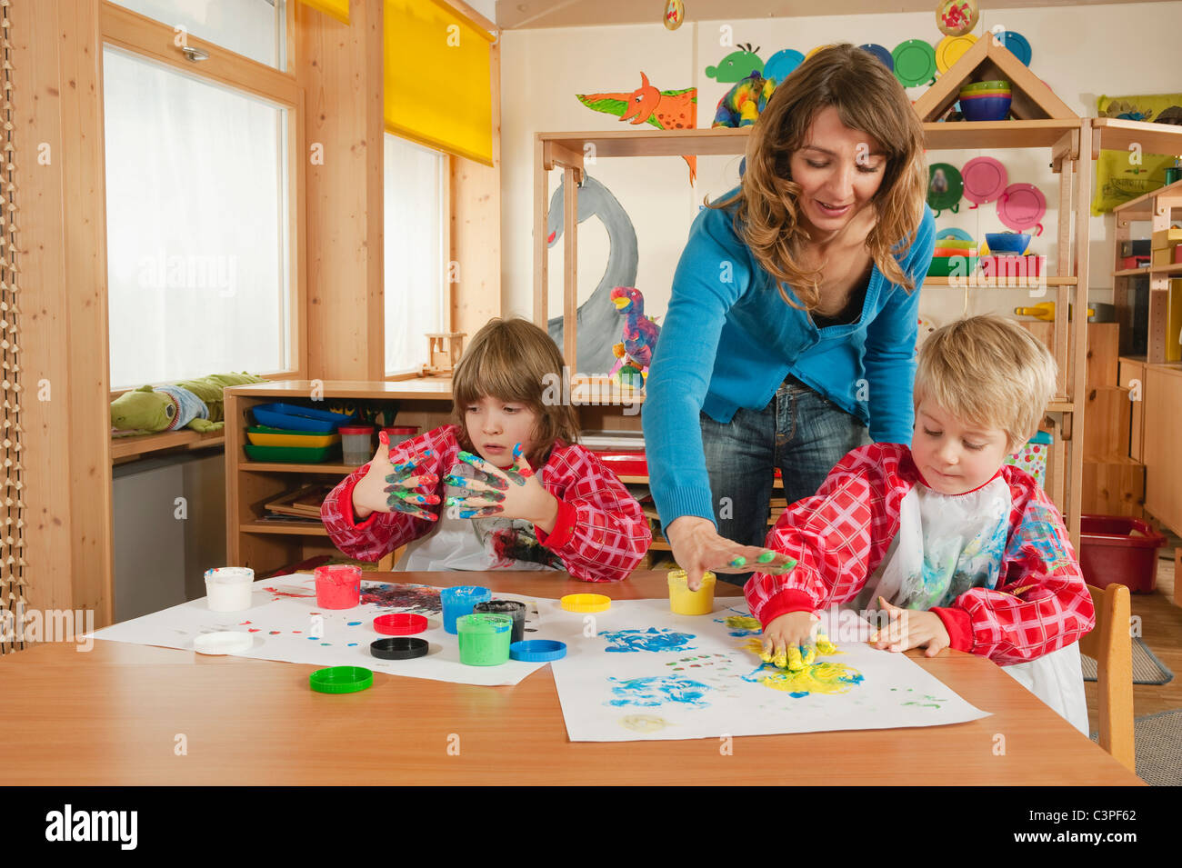 Deutschland, zwei Jungs (3-4), (6-7) Fingerpainting im Kindergarten Stockfoto