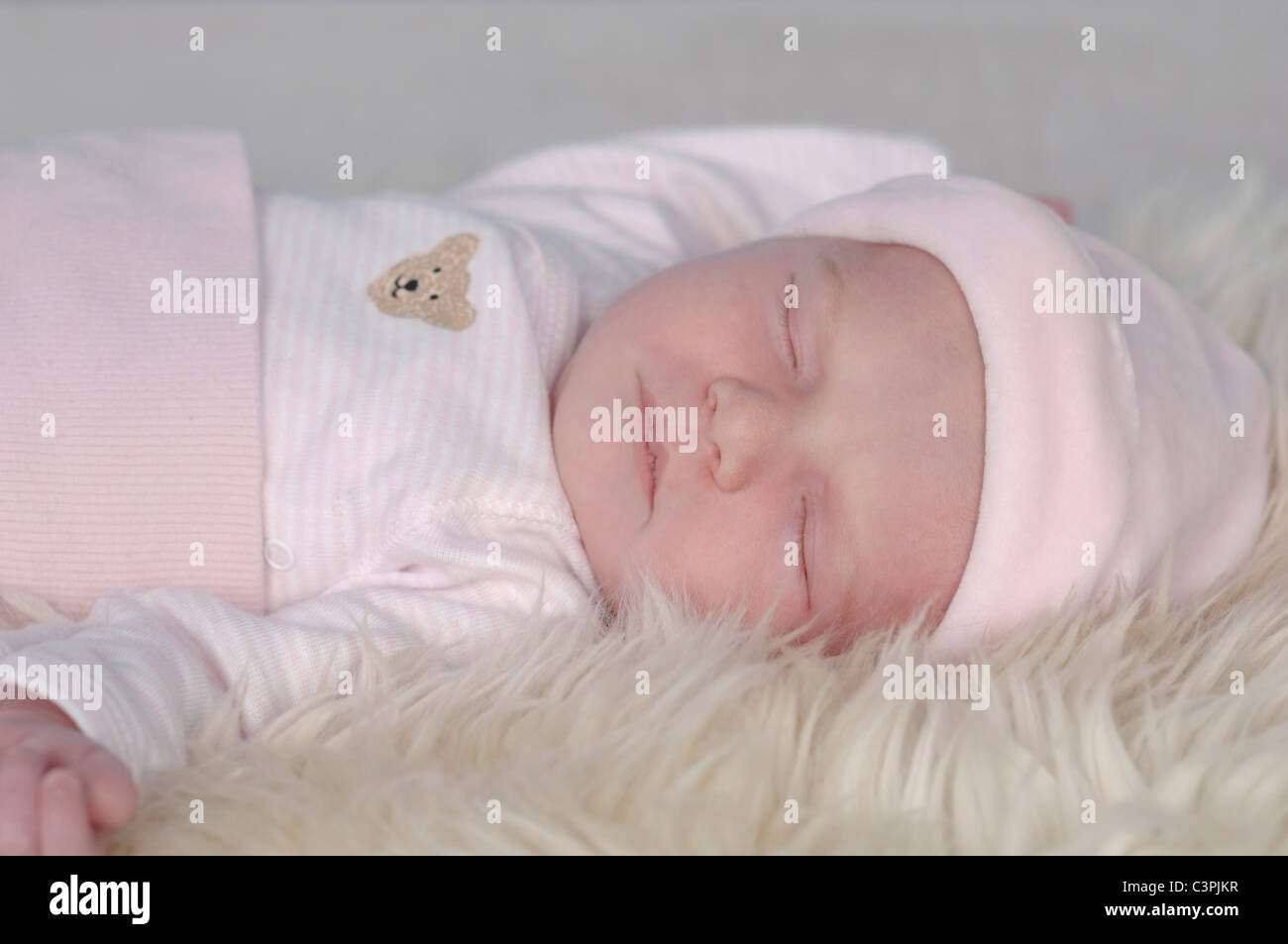 Baby Girl (0-1 Monate) schlafen auf weißem Fell Decke, Nahaufnahme Stockfoto