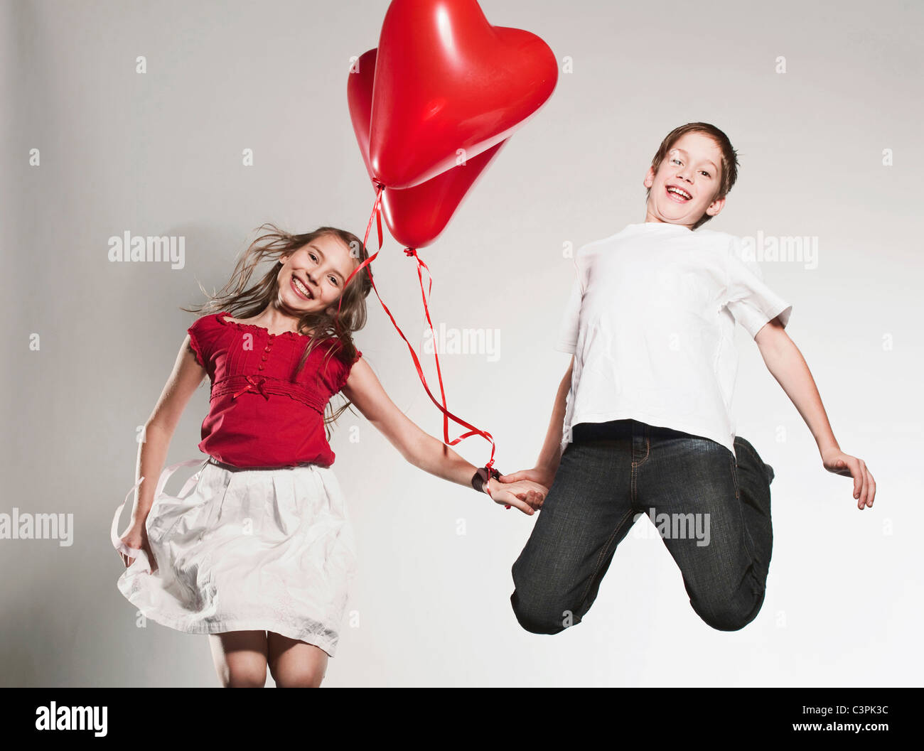 Kinder (10-13) Ballons halten und springen, Lächeln, Porträt Stockfoto