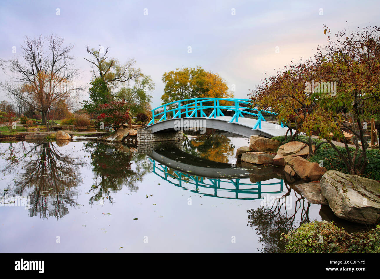 Eine pastorale Szene eine japanische Brücke über einem ruhigen kleinen Teich an einem regnerischen Tag im Herbst, südwestlichen Ohio, USA Stockfoto