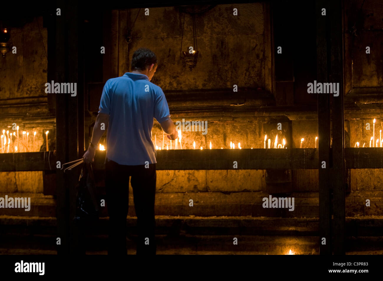 Ein Junge zündet eine Kerze in einem Tempel in Jerusalem. Stockfoto