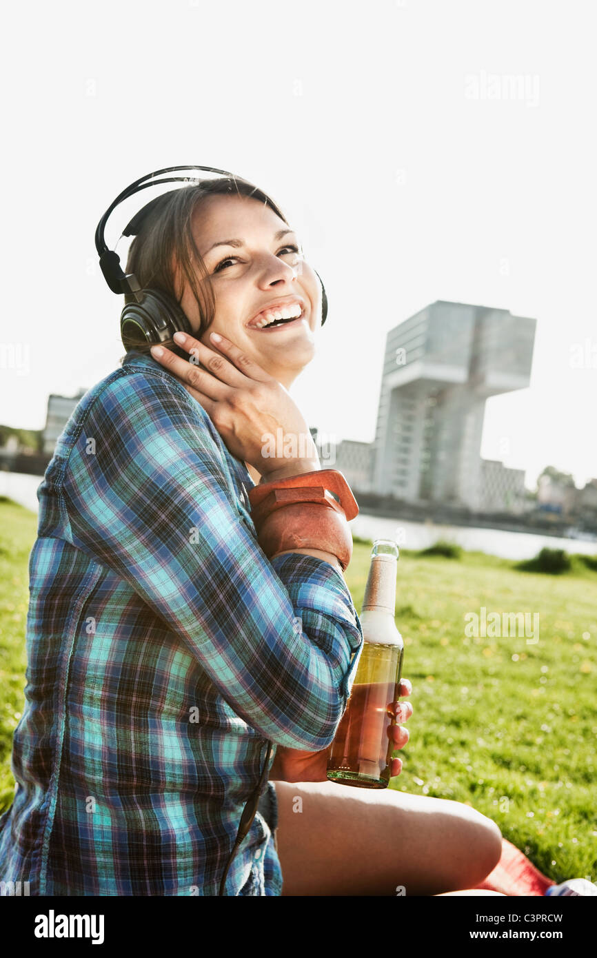 Deutschland, Köln, junge Frau mit Kopfhörer, Lächeln Stockfoto