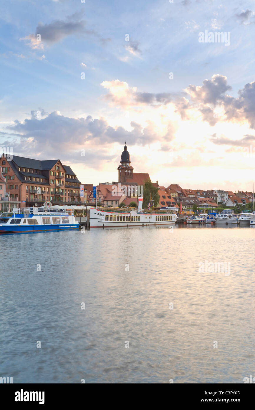 Deutschland, Mecklenburg-Vorpommern, Warener, Blick auf Hafen mit der Stadt in der Abenddämmerung Stockfoto