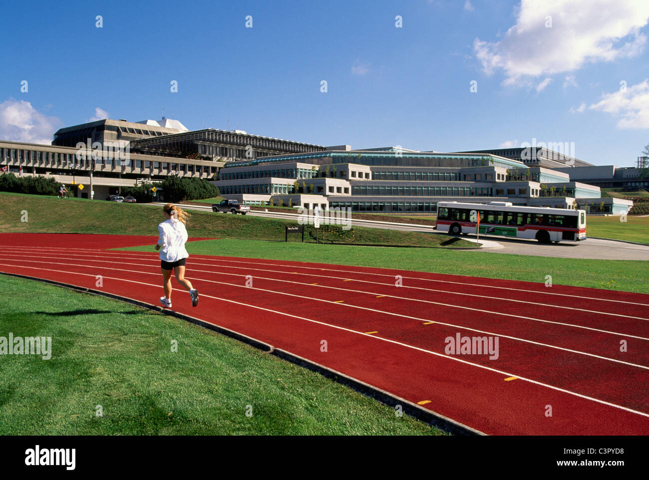 Burnaby, BC, Britisch-Kolumbien, Kanada - Terry-Fox-Feld, Simon Fraser University Campus, Frau auf der Laufstrecke & Feld Bahnen Stockfoto