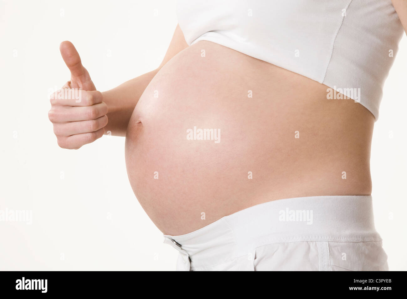 Schwangere Frau zeigt Daumen hoch Zeichen, Mids exion Stockfoto