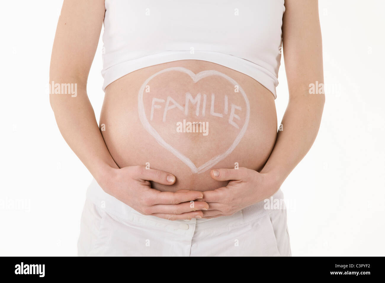 Herzform gezeichnet auf schwangere Frau Bauch mit Text, Mittelteil Stockfoto
