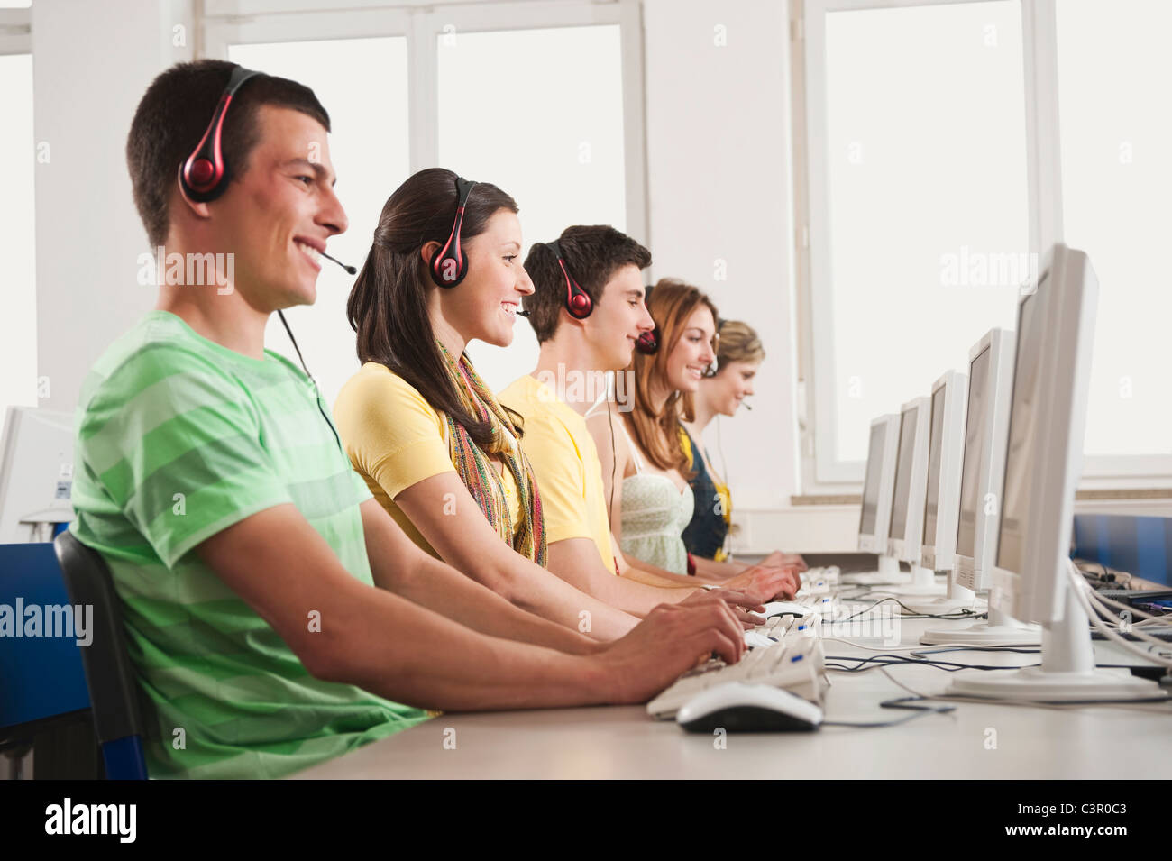 Deutschland, Emmering, Studenten, die mit Computer im Computerraum, Lächeln Stockfoto