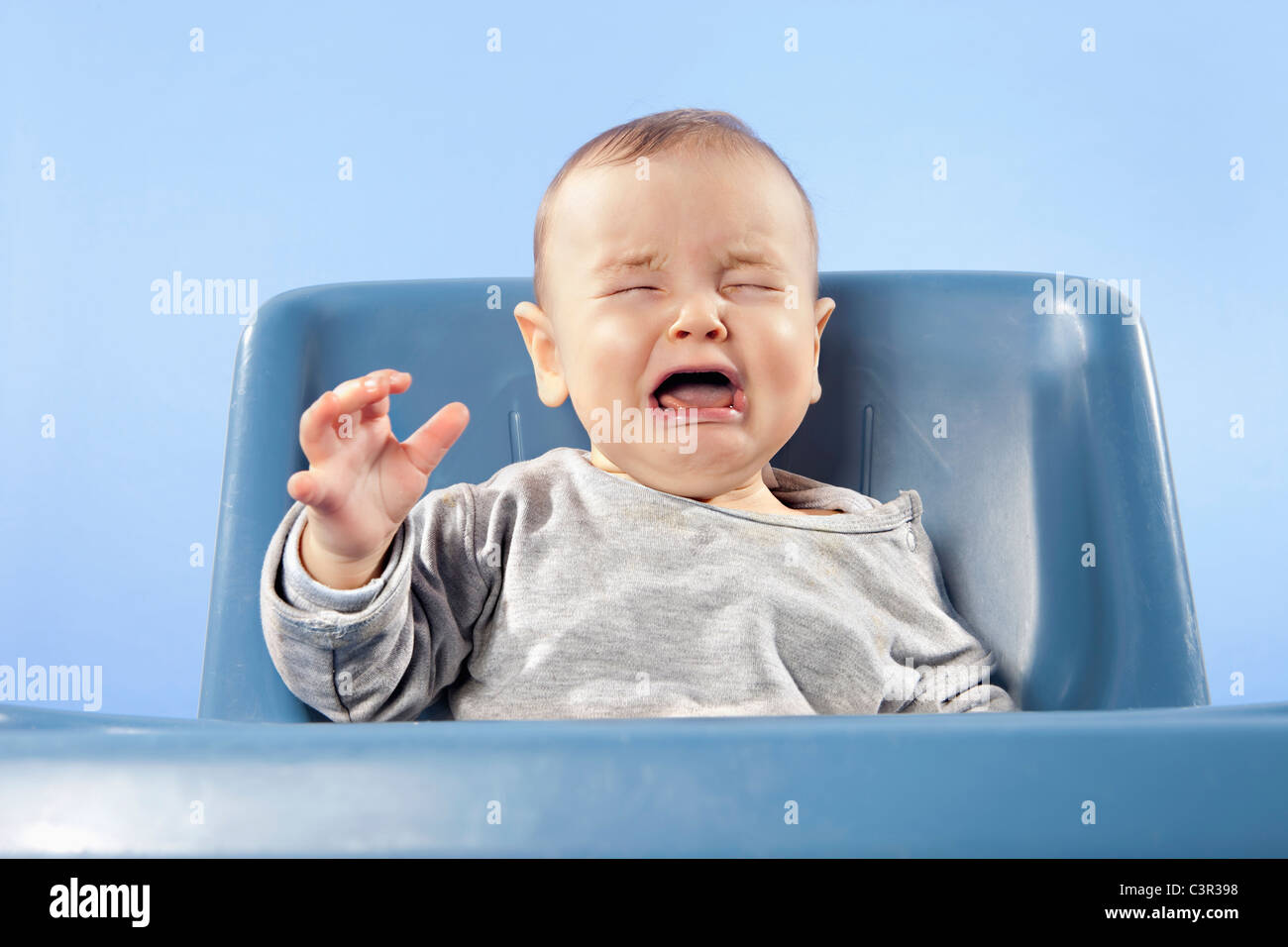 Baby Boy (6-11 Monate) im Hochstuhl Weinen, Augen geschlossen Stockfoto