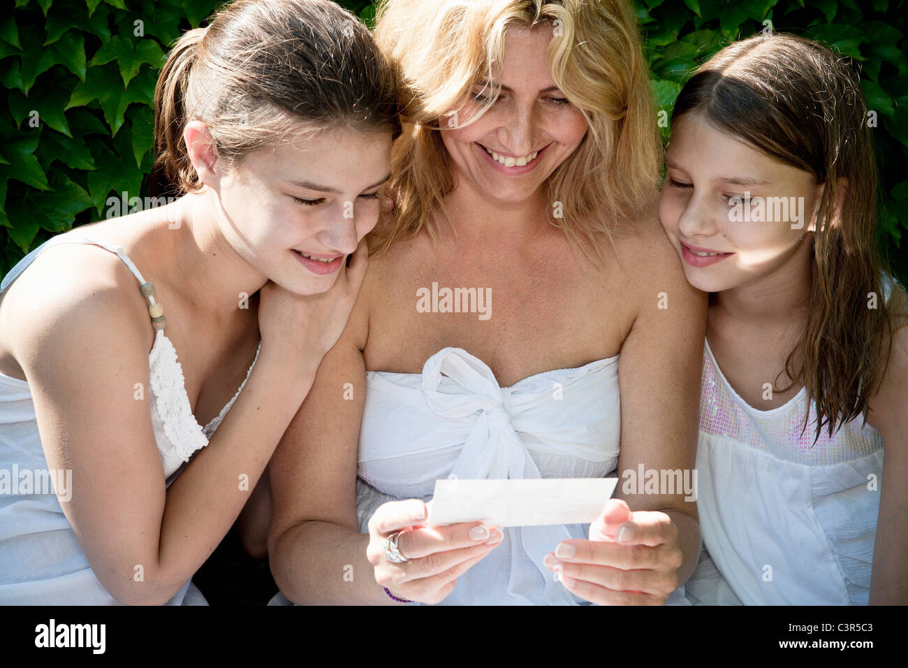 Mutter und Töchter schauen Sie sich Fotos Stockfoto