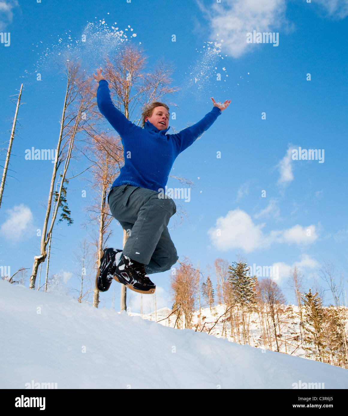 Mann springt in Schnee Stockfoto