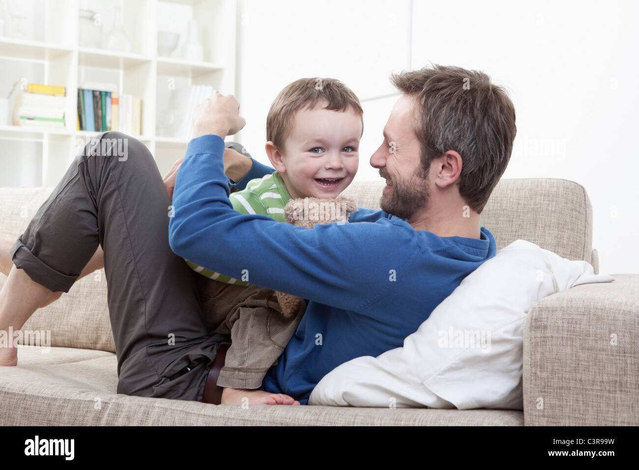 Deutschland, Bayern, München, Vater und Sohn (2-3 Jahre) Spaß auf sofa Stockfoto