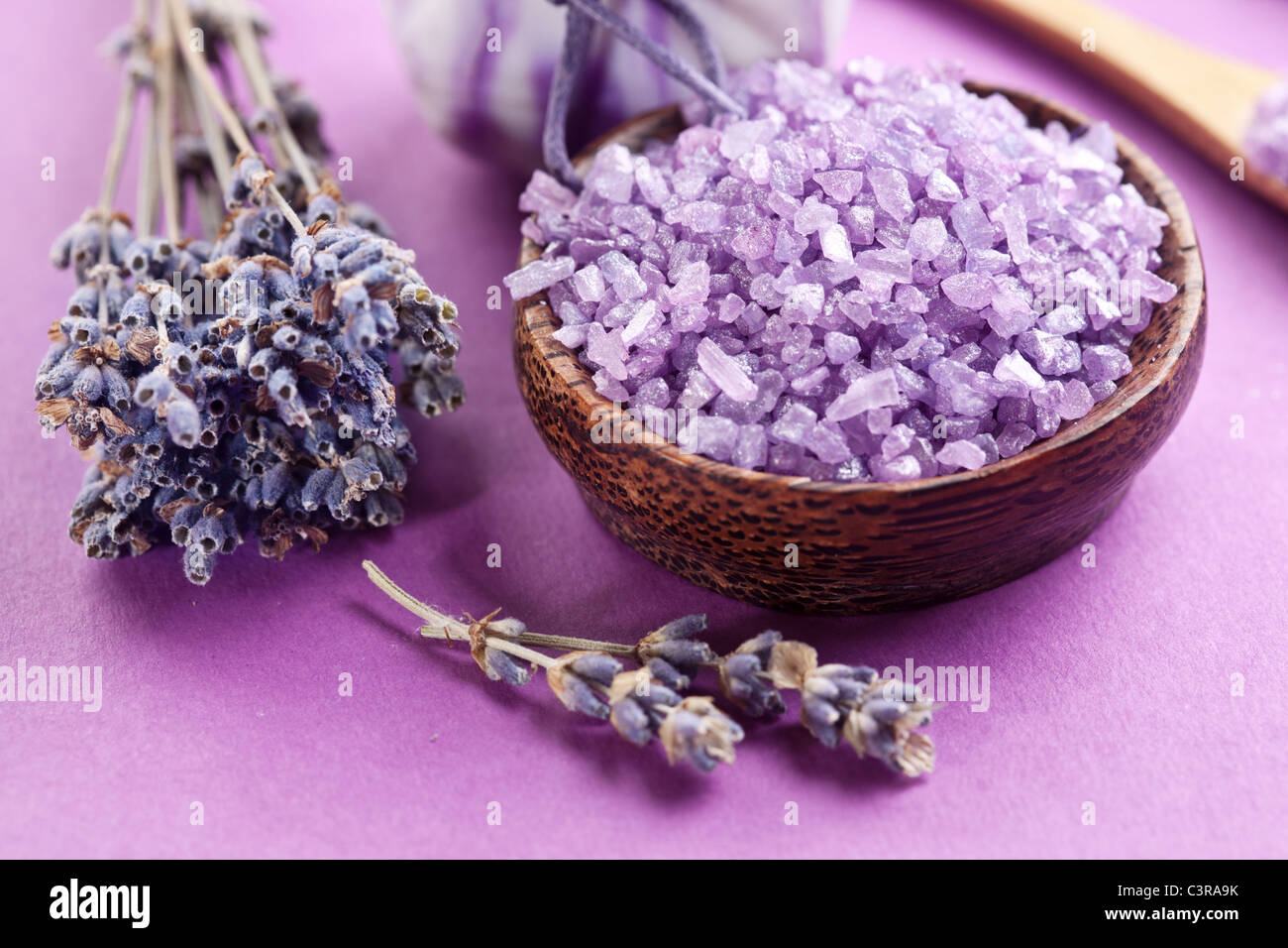 Meersalz und getrocknetem Lavendel auf violettem Hintergrund. Stockfoto