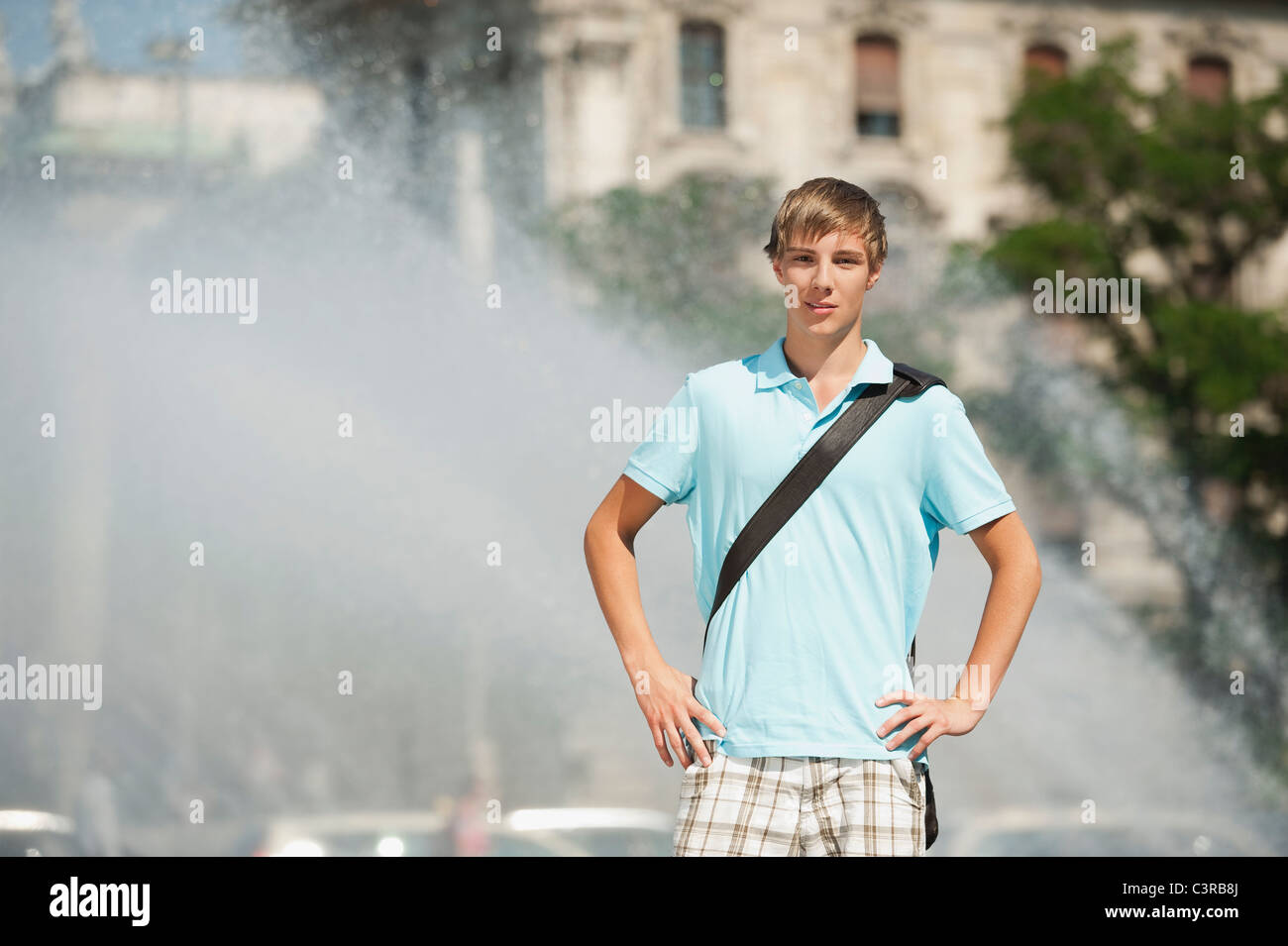 Deutschland, München, Karlsplatz, junger Mann, der am Brunnen, Porträt Stockfoto