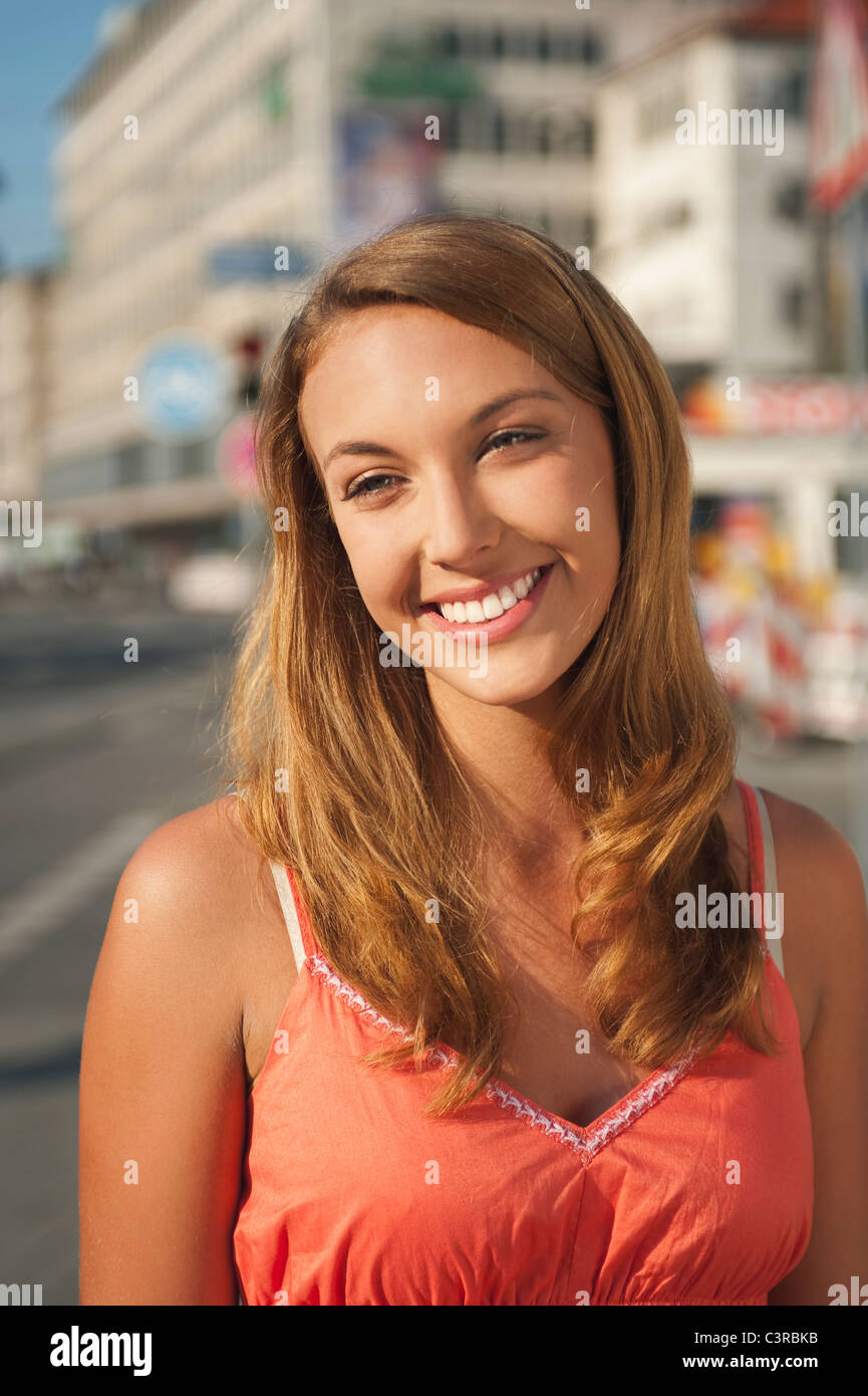 Deutschland, München, Karlsplatz, junge Frau wegsehen, Lächeln Stockfoto