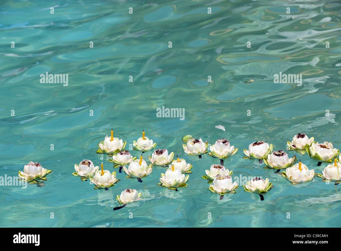 Lotusblüte mit Kerzen auf klaren, blauen Wasser treiben, Thailand Stockfoto