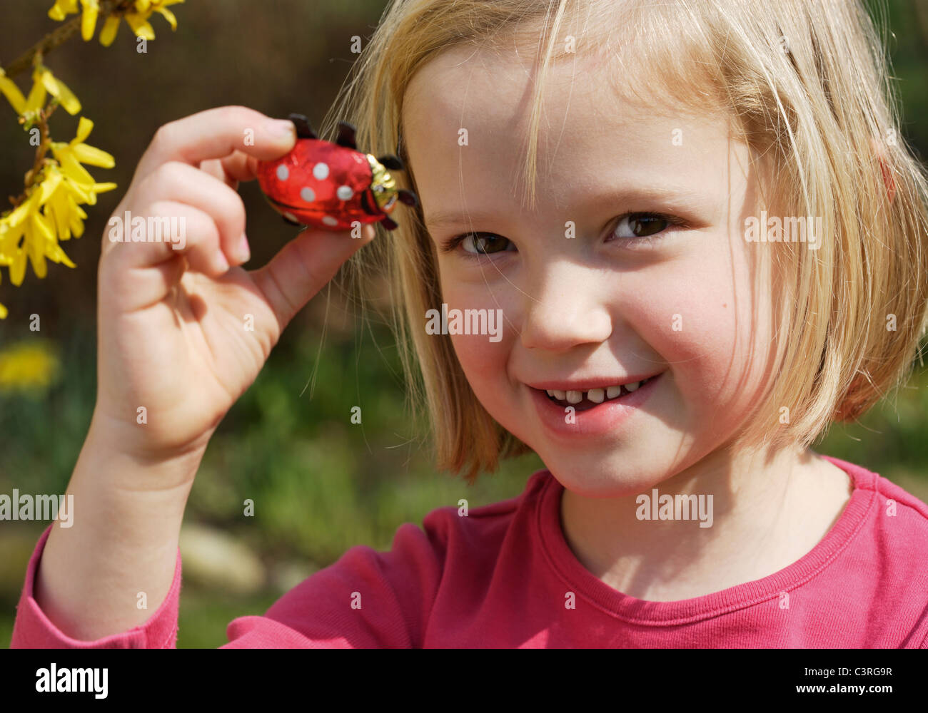 Deutschland, Bayern, Mädchen (6-7 Jahre) hält Ostern Schokolade Käfer, Porträt, Lächeln Stockfoto