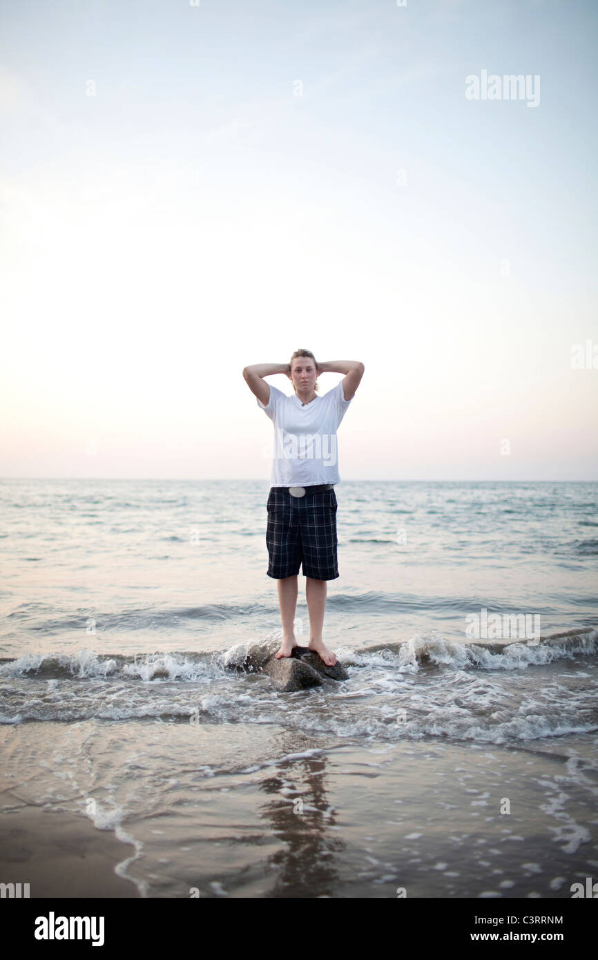 Kaukasische Frau stehen auf Felsen im Meer Stockfoto