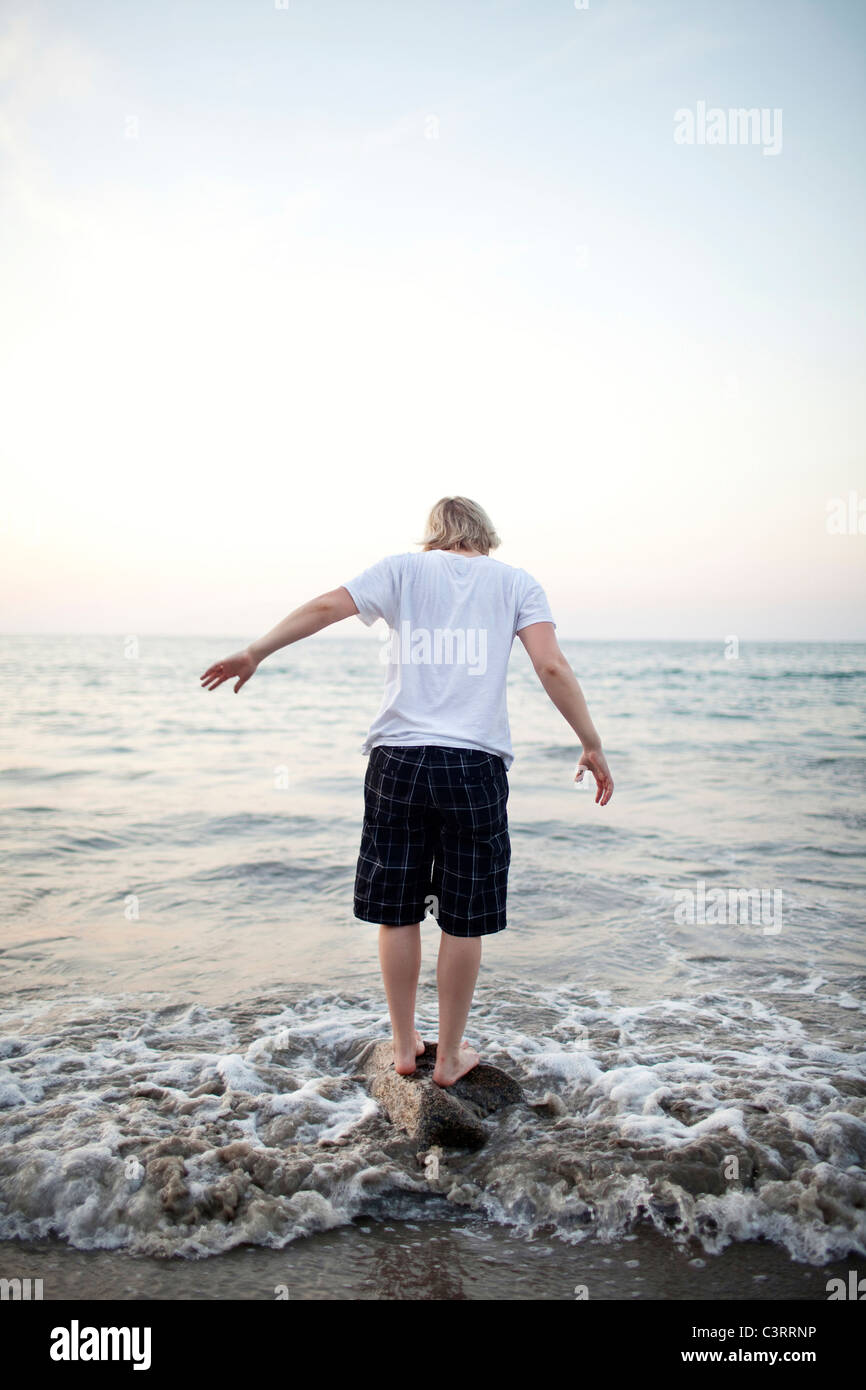 Kaukasische Frau stehen auf Felsen im Meer Stockfoto