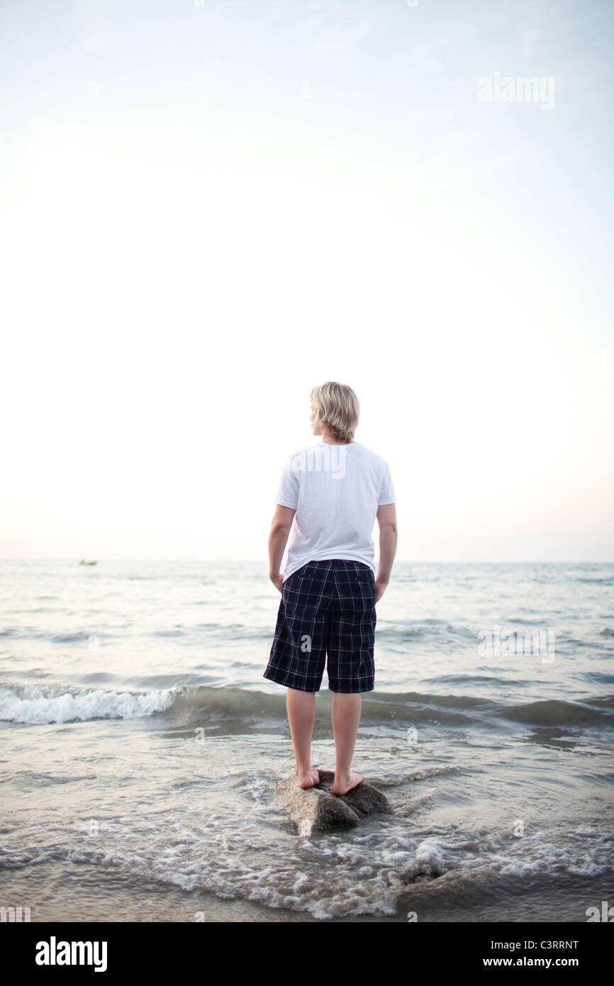 Kaukasische Frau stehen auf Felsen im Meer Stockfoto