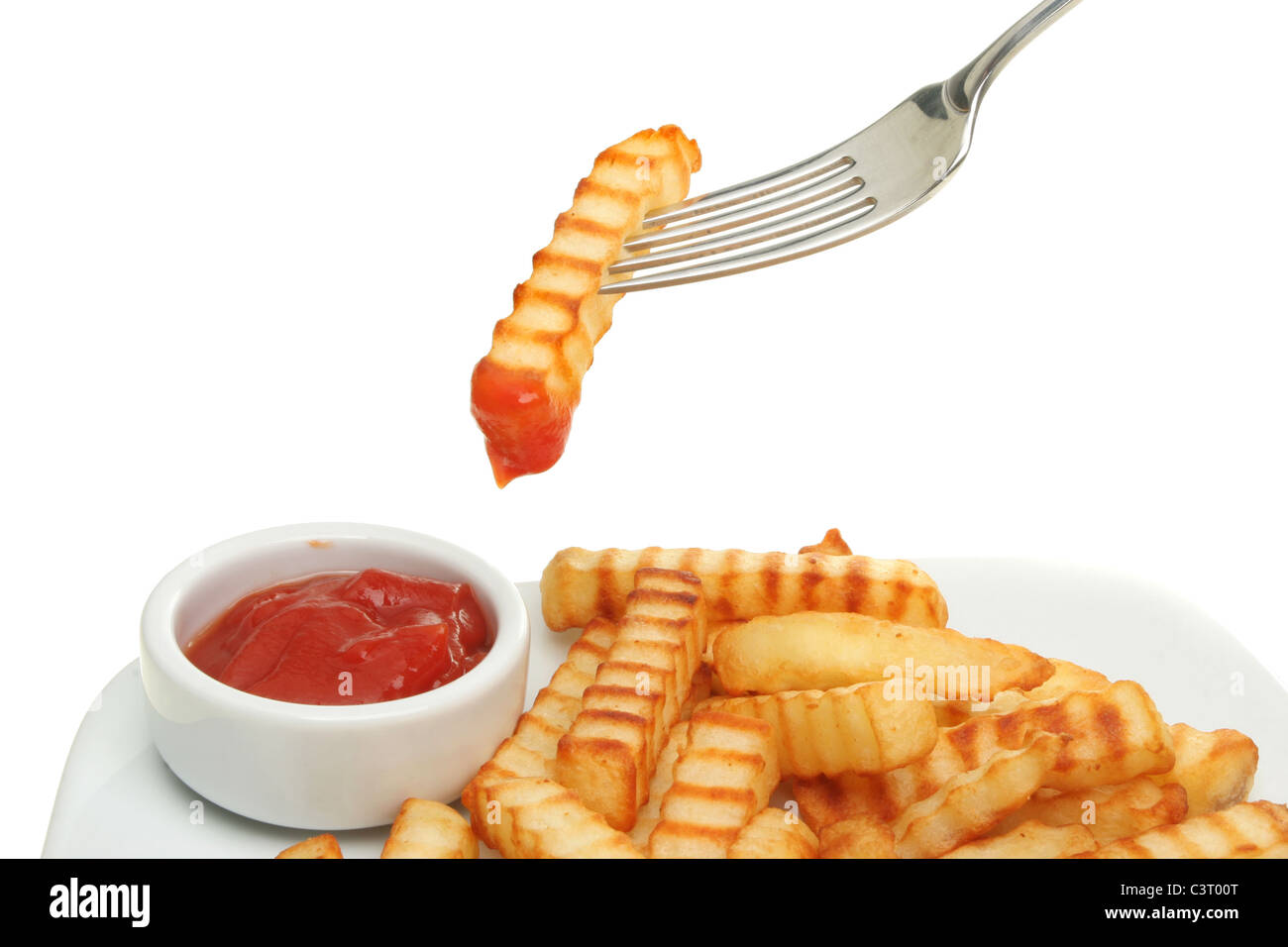 Crinkle geschnittene Kartoffelchips und Tomaten-Ketchup mit einem Chip, eingetaucht in Ketchup auf einer Gabel Stockfoto