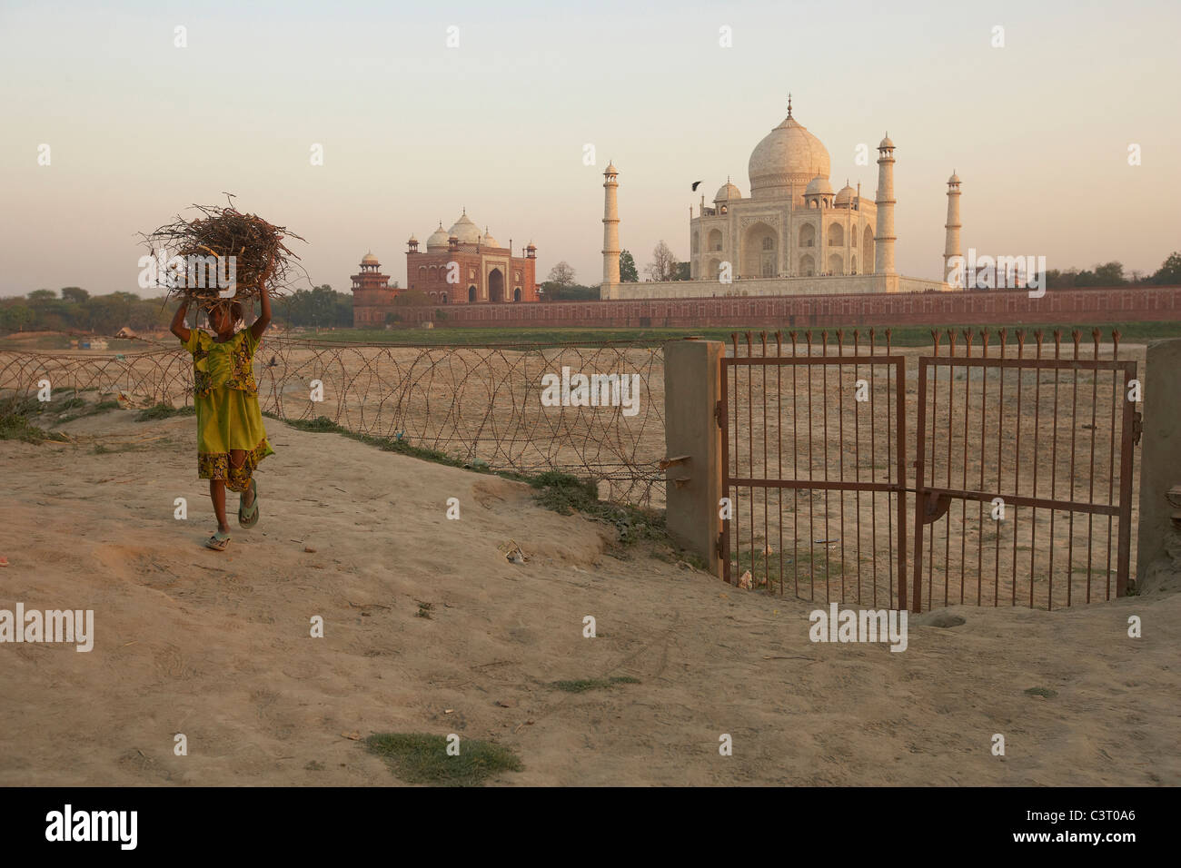 Mädchen tragen Stöcke vor dem Taj Mahal am Ufer des Flusses Yamuna, Agra, Indien Stockfoto