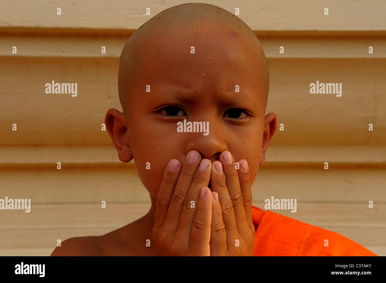 SAGEN NO EVIL, junge Novizin machen die drei weisen Affen, die sprichwörtliche Prinzip, Wat Santithammaram, Bangkok, thailand Stockfoto