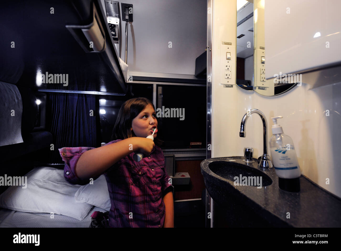 2010. 10 Jahre alten Mädchen Bürsten ihre Zähne vor dem Bett in ihrem Amtrak-Schlafwagen für die Reise von Chicago nach Washington, DC. Stockfoto