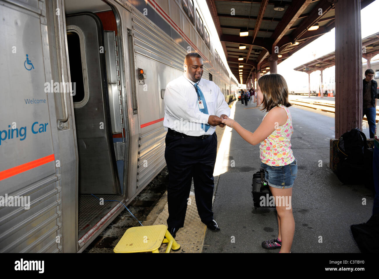 2010. 10 jährige Mädchen gibt Ticket für Auto Steward auf der Amtrak-Schlafwagen auf dem Capitol Limited von Chicago nach Washington D.C. Stockfoto