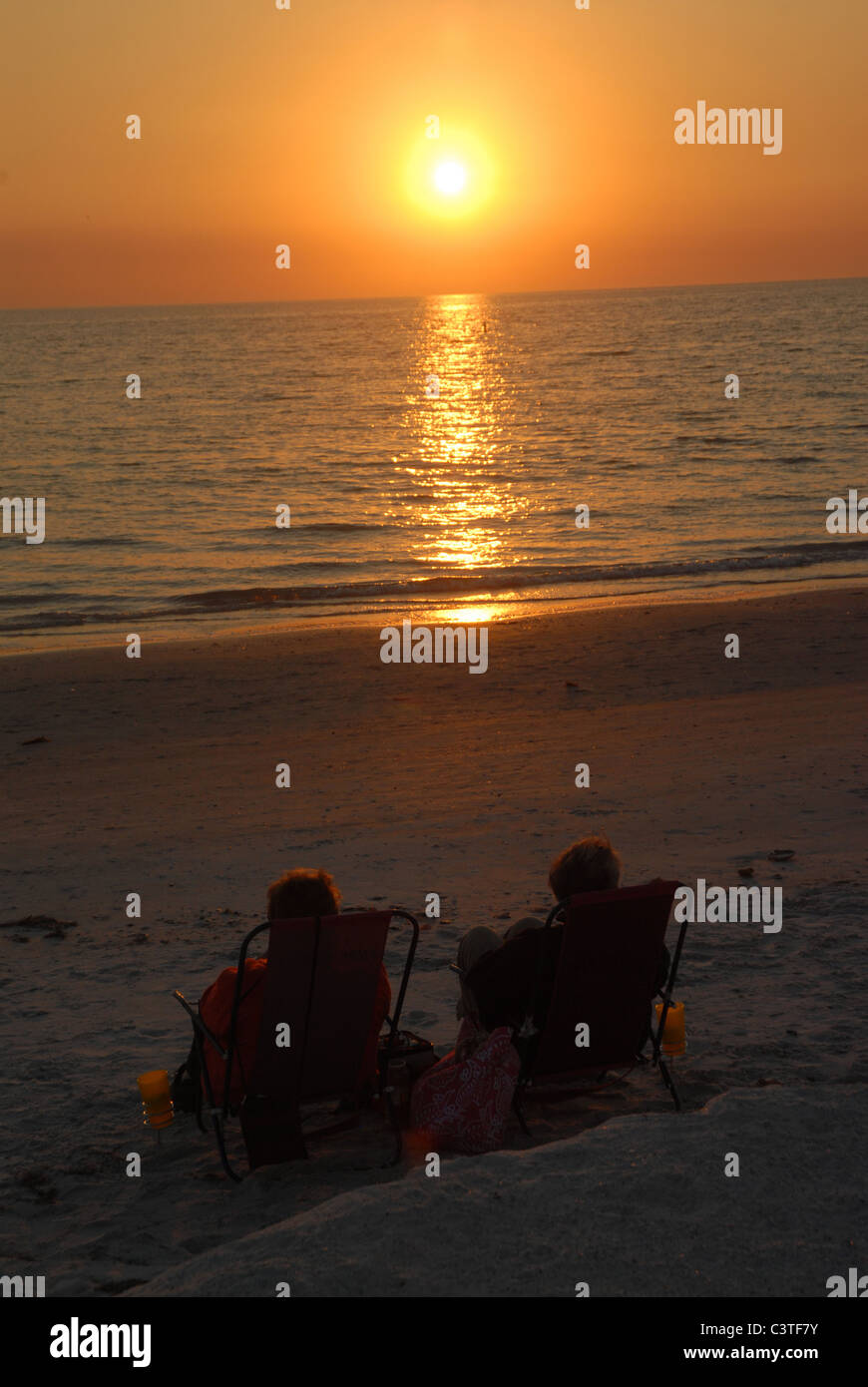 Die Sonne geht da zwei Leute zu beobachten, dass die Sonne St. Pete Beach, Florida eingestellt. Stockfoto