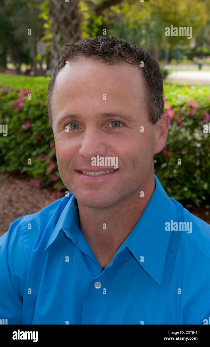 Porträt des Mannes im Alter von 30 Sekunden im Freien im Park mit blauem Hemd Stockfoto