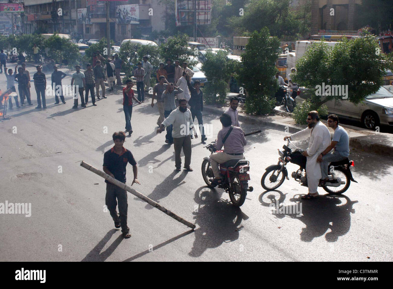 Wütender Anwohner stoppen Autofahrer um vorwärts zu bewegen, wie sie gegen Strom Lastabwurf in ihrem Gebiet in Karachi protestieren Stockfoto