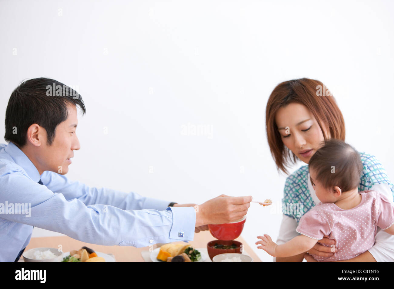 Vater Feeding Baby Girl Stockfoto