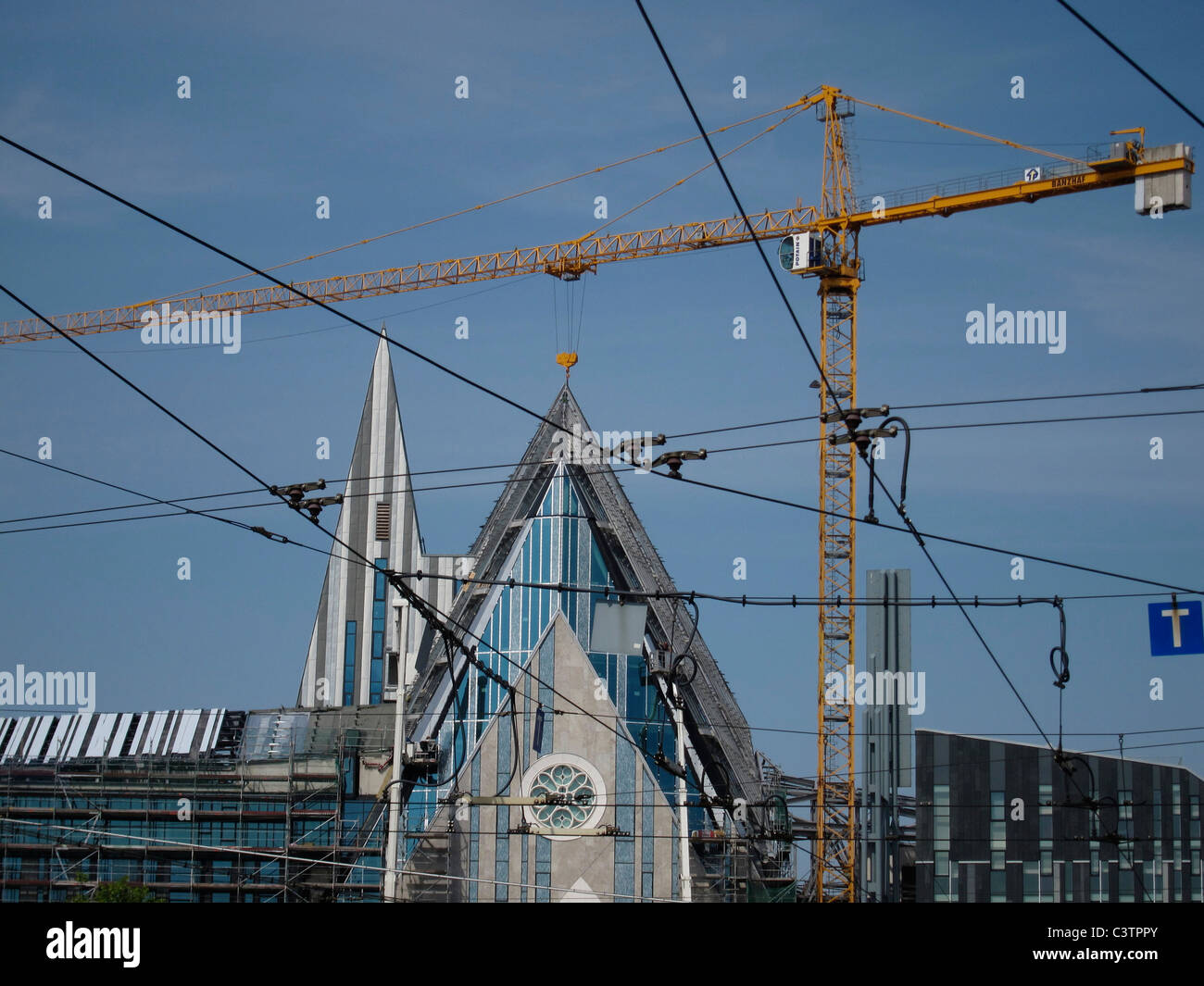 Ein Baukran ist durch die Straßenbahn Drähte in Leipzig Deutschland gesehen. Stockfoto