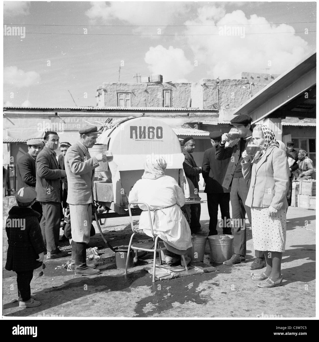 der 1950er Jahre in dieses Geschichtsbild durch J Allan Cash sind Männer und Frauen an einem tragbaren Bier Stand in Buchara, Usbekistan trinken. Stockfoto