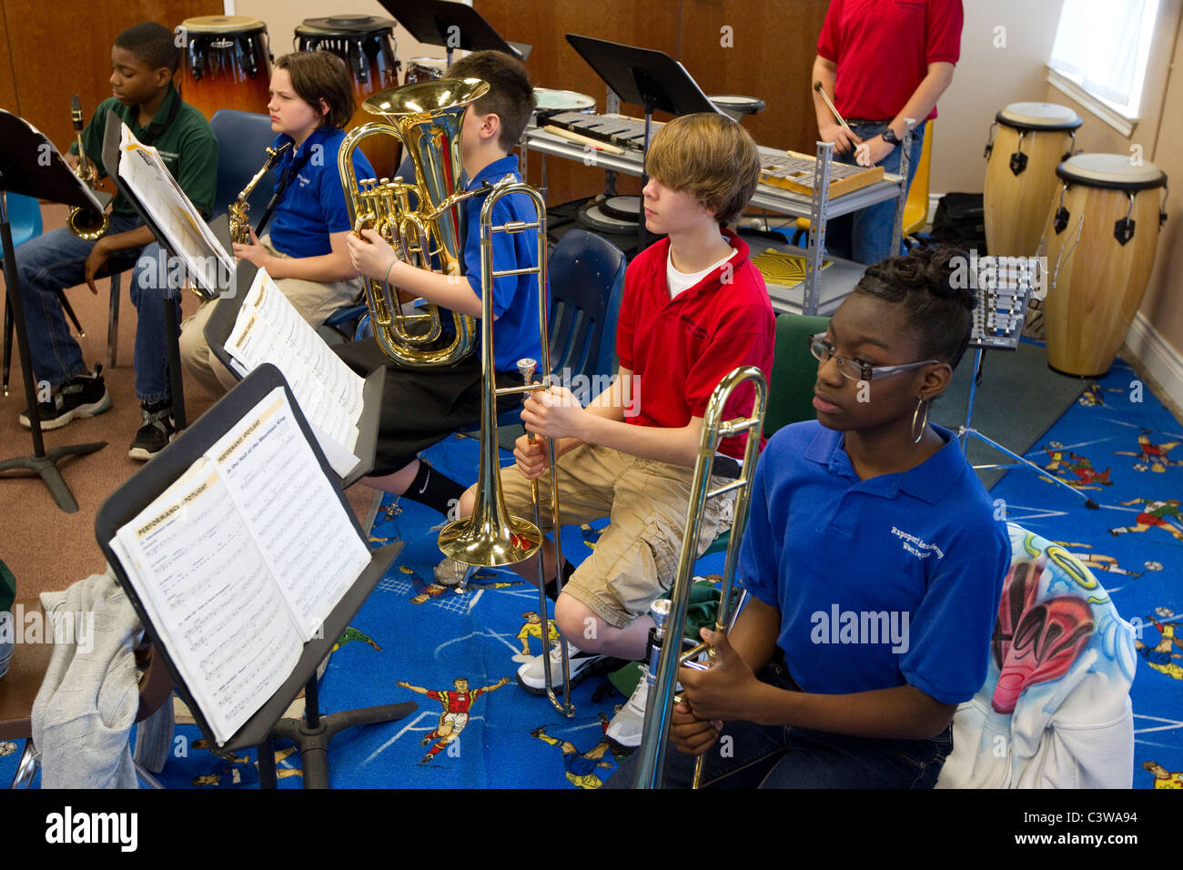 Anglo, bereiten Hispanic und Afro-Amerikaner Mittelschüler / innen, Blechblasinstrumente während Orchester Klasse spielen Stockfoto