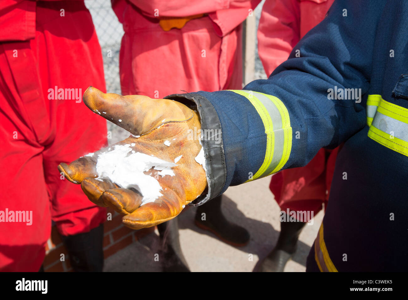 Ein Feuerwehrmann Demostrates der gefrorene Rückstand aus einem C02-Feuerlöscher. Stockfoto