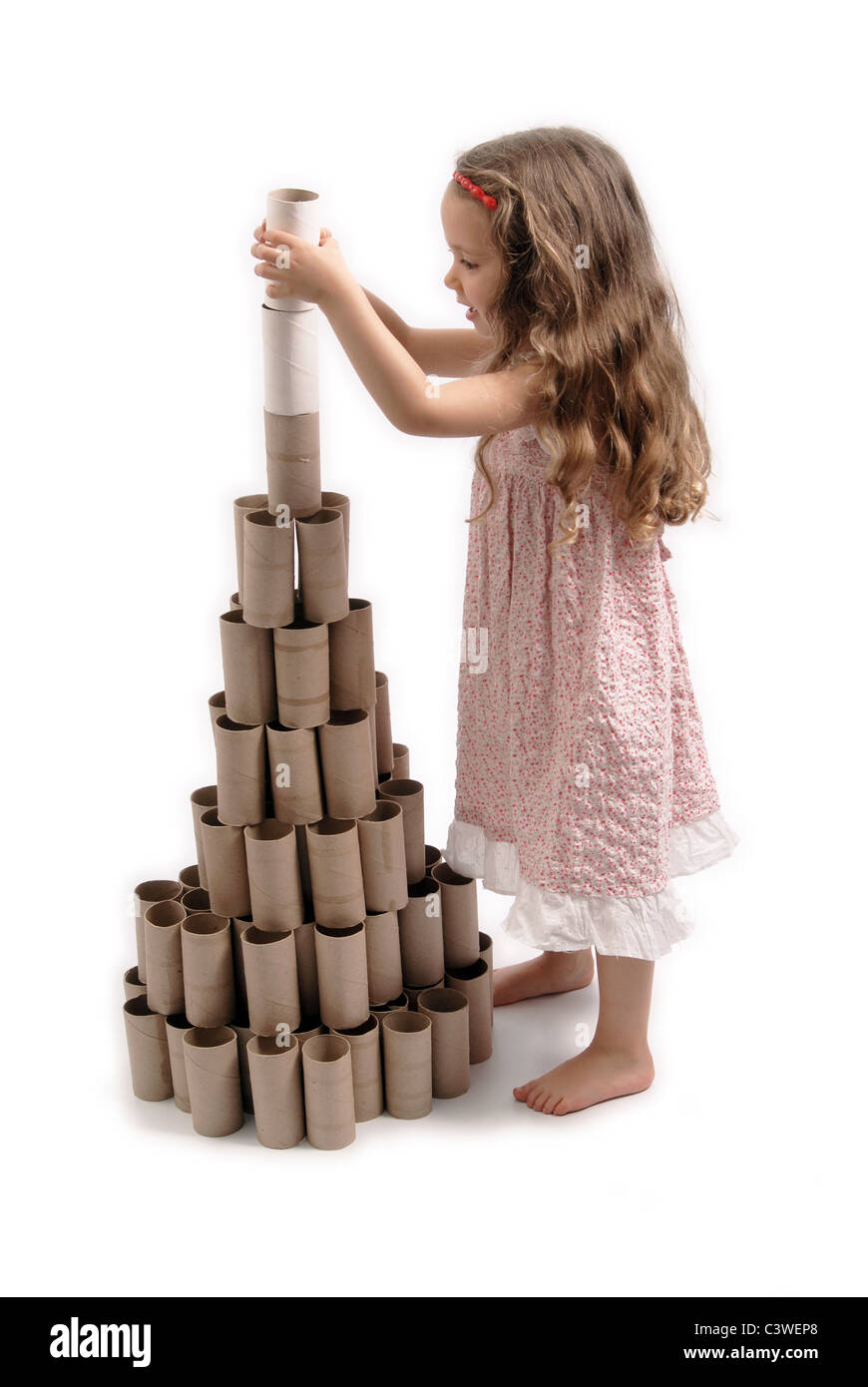 Glückliches kleine Mädchen machen einen Weihnachtsbaum mit Karton Rollen Toilettenpapier. Weißen Hintergrund. Stockfoto