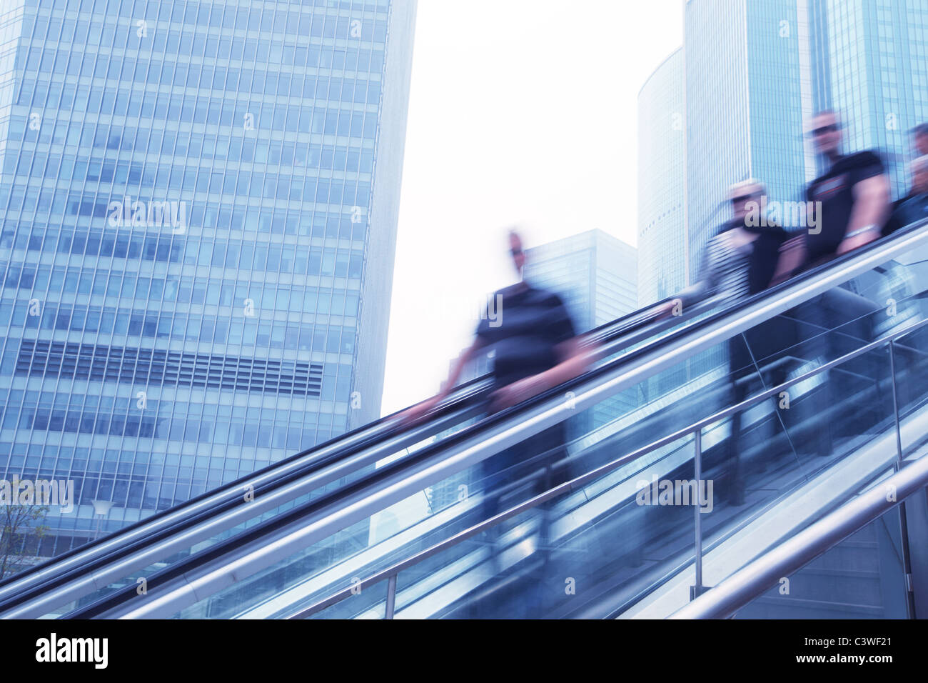 Städtereisende auf Rolltreppe, Bewegungsunschärfe. Stockfoto