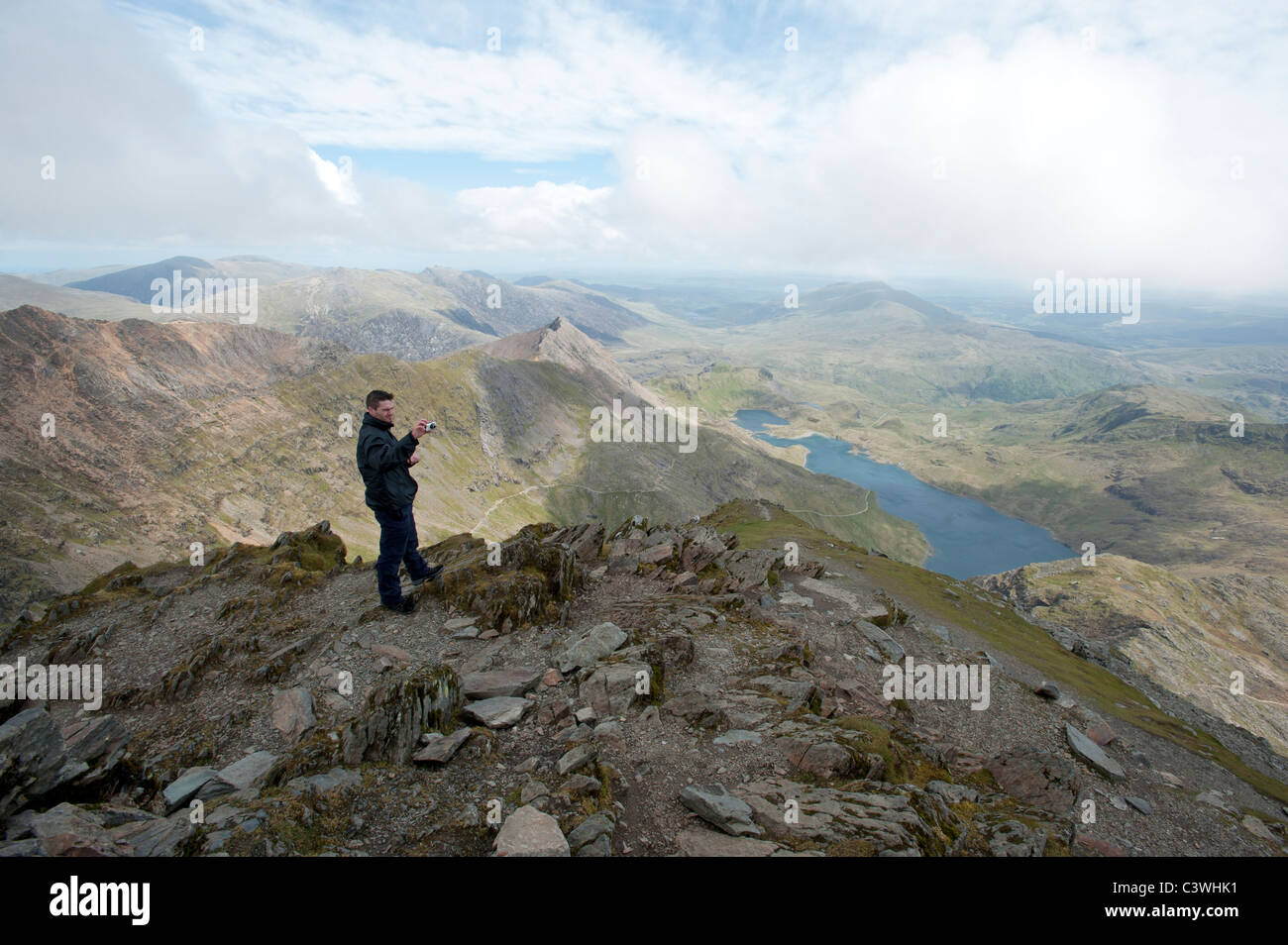 Ein Rambler mit dem Fotografieren auf dem Gipfel des Mount Snowdon, der höchste Berg in Wales Stockfoto