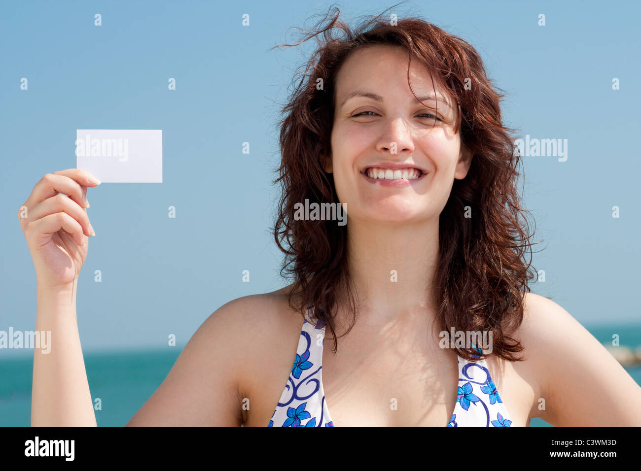 Frau mit Visitenkarte am Strand Stockfoto