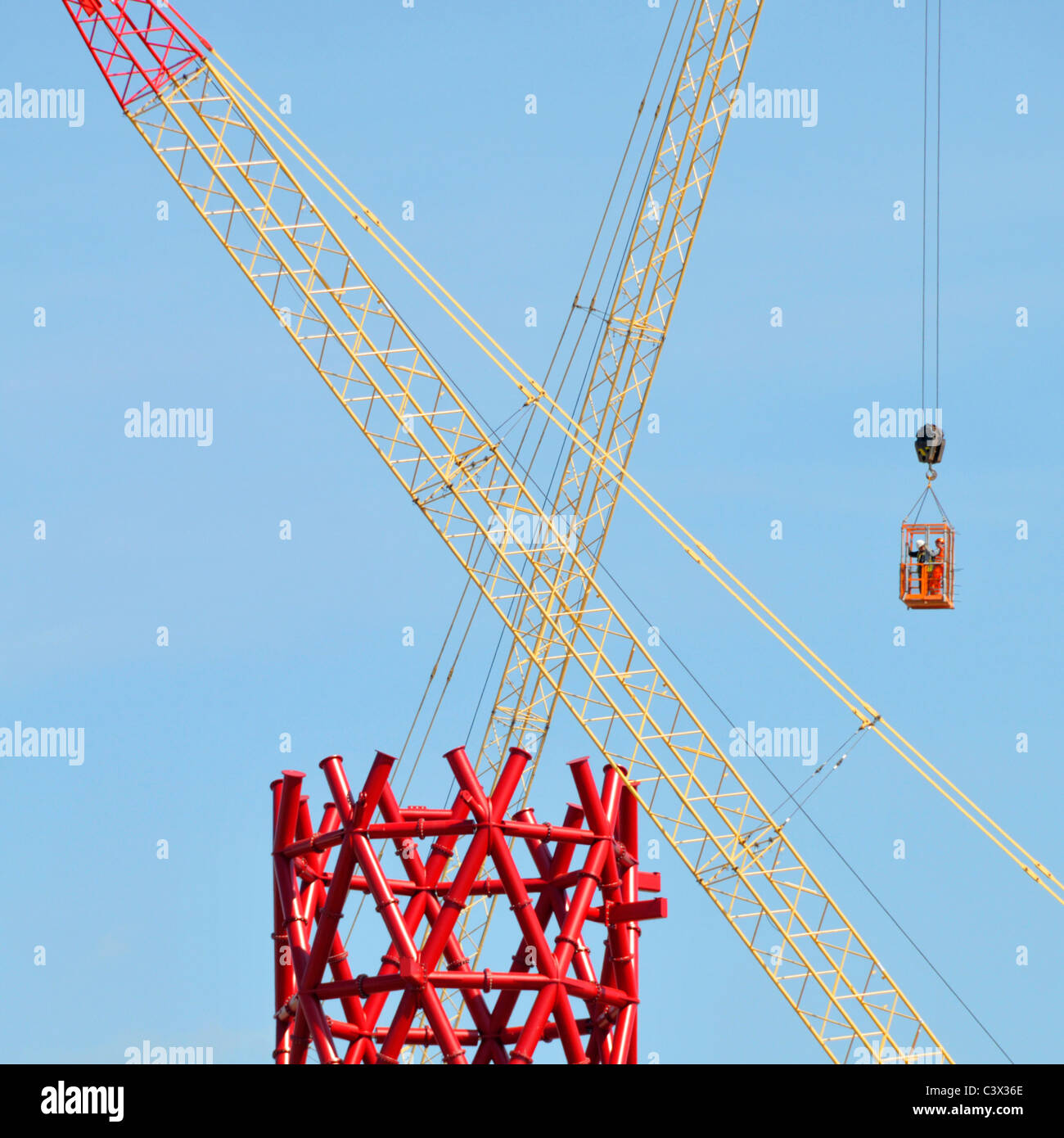 Baukräne Kreuz und Roten Baustahl core ArcelorMittal Orbit Turm zwei Arbeiter der Luft in den Käfig Olympischen Spiele 2012 in London Großbritannien Stockfoto