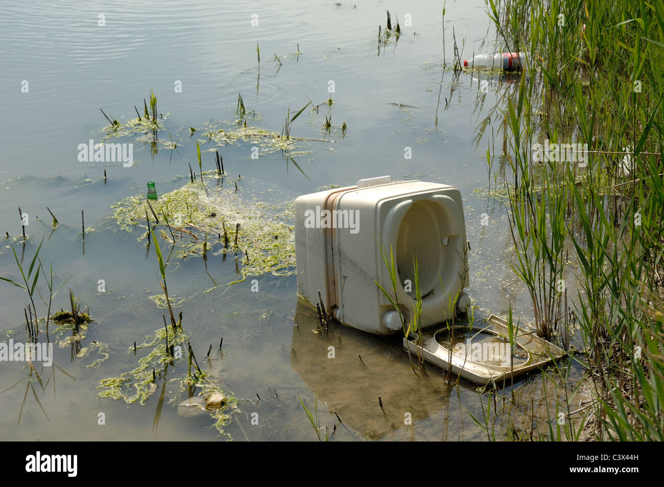 Fly Tipping oder Fly Dumping von weggeworfenen tragbaren Toilette oder Plastikmüll in den Feuchtgebieten Camargue Provence Frankreich geworfen Stockfoto